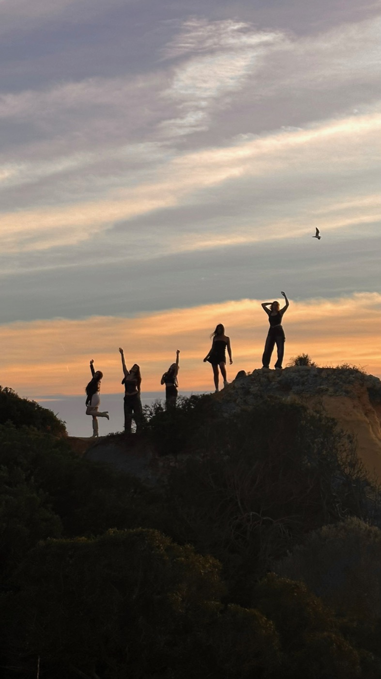 Silhouetten der Gruppe auf den Klippen im Sonnenuntergang