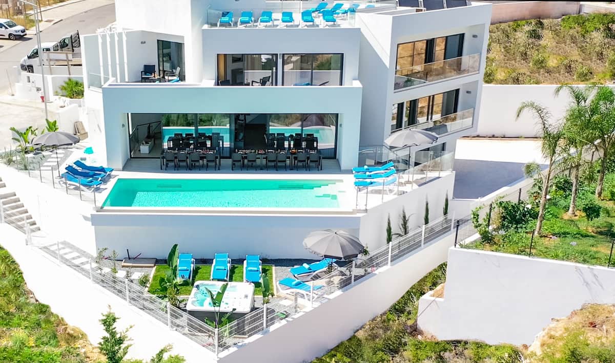 Die Villa in Armação de Pêra von oben: weißes Haus mit Pool, Sonnenliegen und Terrassen im Grünen