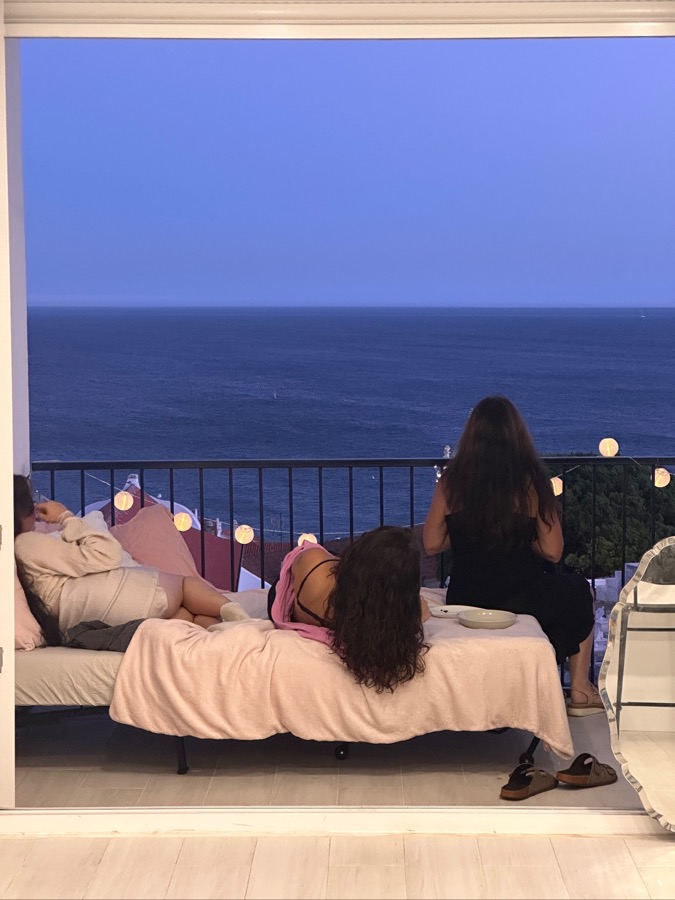 Freundinnen schauen abends gemeinsam aufs Meer